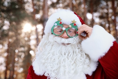 Photo of Happy Authentic Santa Claus with funny glasses outdoors, space for text