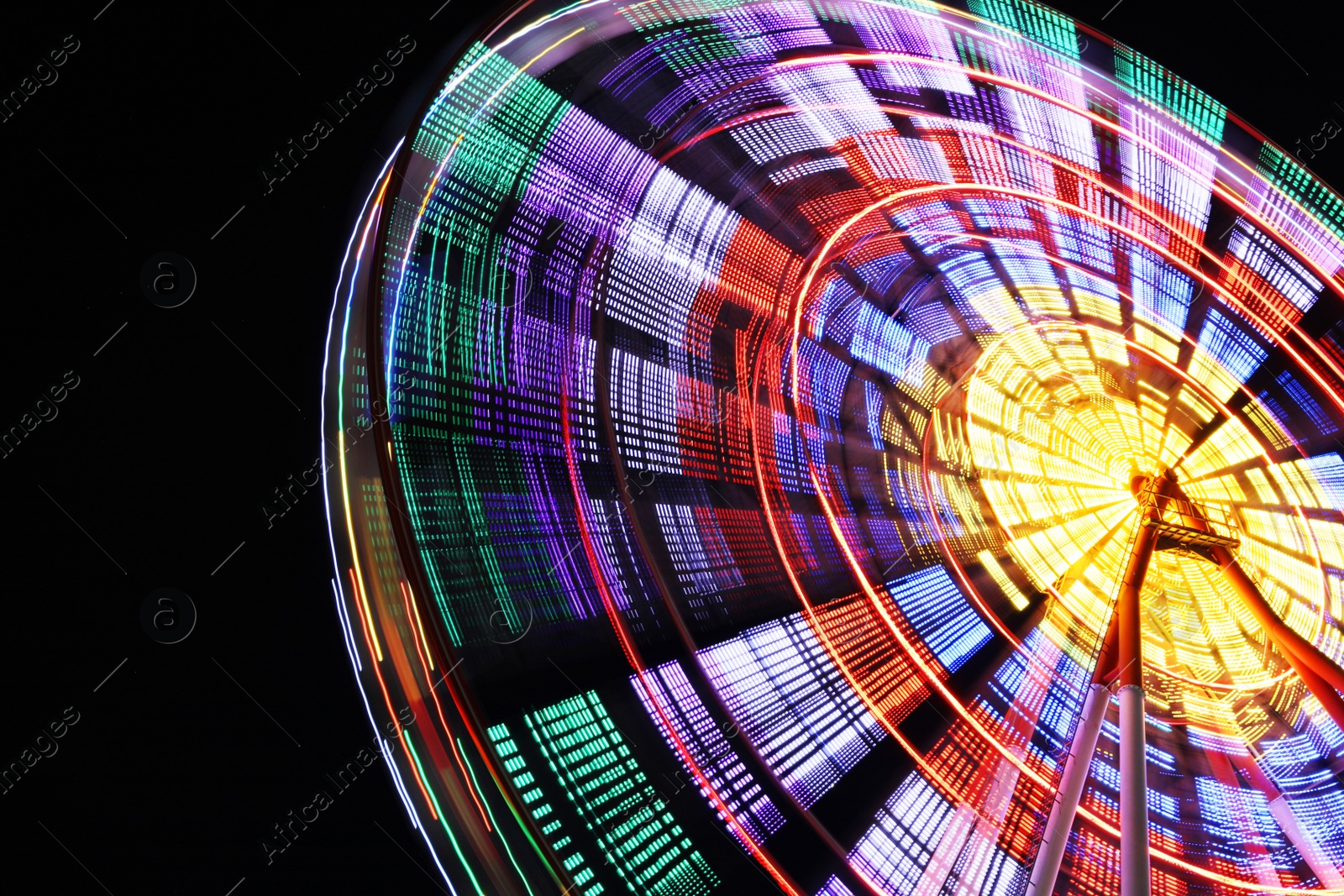 Photo of Beautiful glowing Ferris wheel against dark sky, low angle view