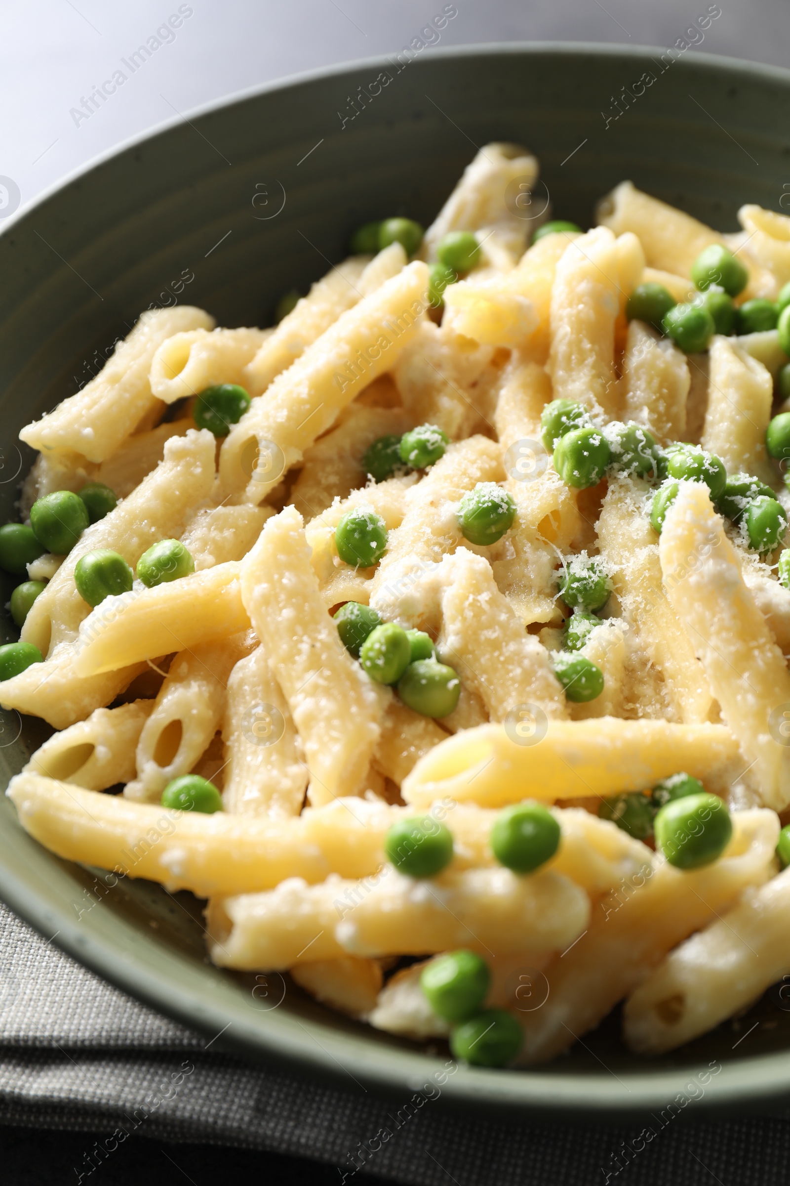 Photo of Delicious pasta with green peas and cheese on table, closeup