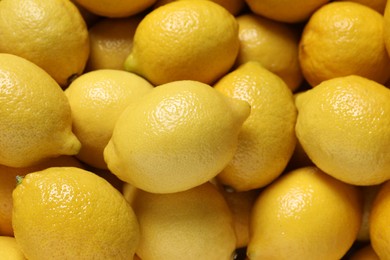 Photo of Fresh lemons as background, closeup. Citrus fruit