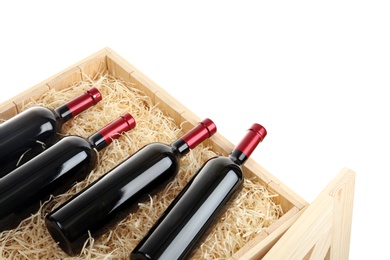 Photo of Bottles of wine in open wooden crate isolated on white