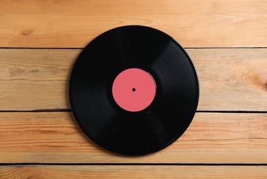 Vintage vinyl record on wooden background, top view
