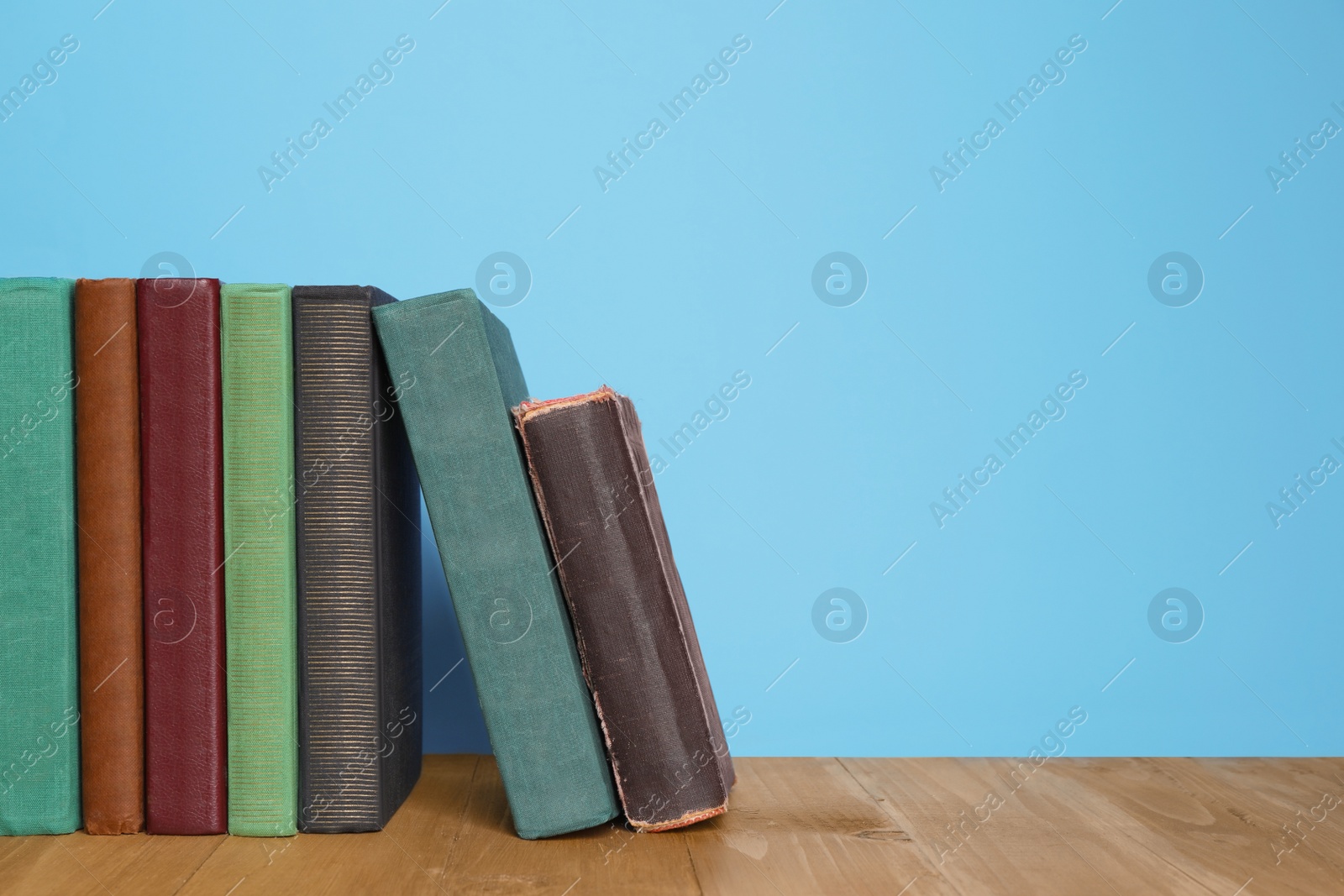 Photo of Many old hardcover books on wooden table, space for text