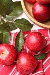 Photo of Fresh red apples with leaves on white table, flat lay