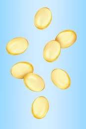 Image of Vitamin. Softgel capsules falling on light blue gradient background