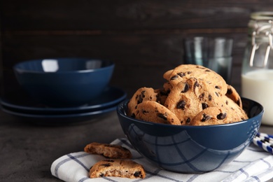 Bowl with tasty chocolate chip cookies on table