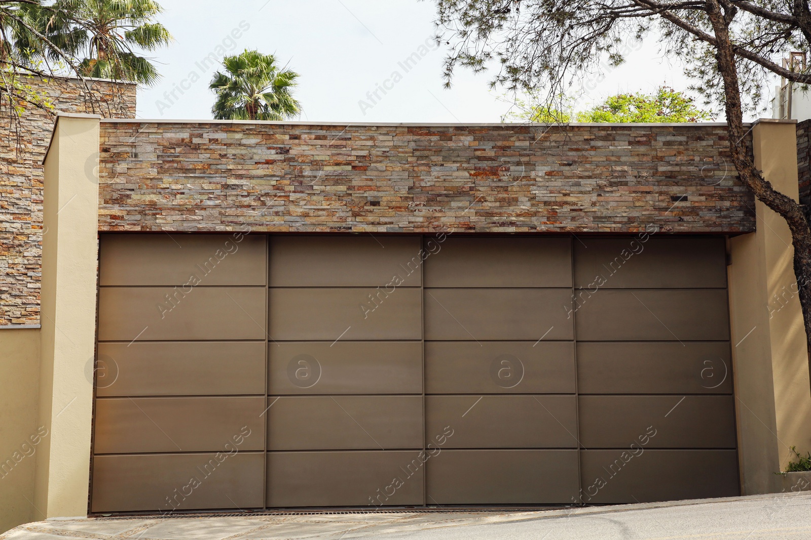 Photo of Brown garage with closed sectional door. Exterior design