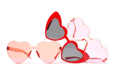 Different stylish heart shaped glasses on white background