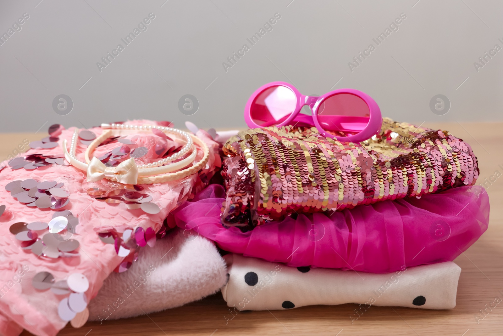 Photo of Stylish carnival costume with sequins, sunglasses and headbands on wooden table