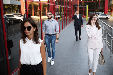 Different people walking on modern city street
