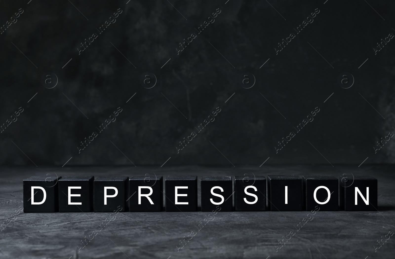 Photo of Word Depression made of black wooden cubes on table. Space for text