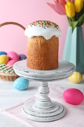 Photo of Easter cake, colorful eggs and tulips on white wooden table