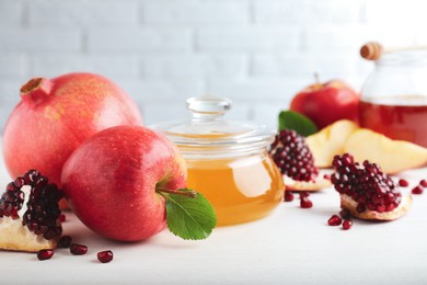 Photo of Honey, pomegranate and apples on white wooden table, closeup. Rosh Hashana holiday