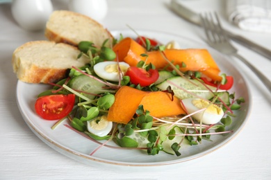 Photo of Salad with fresh organic microgreen in plate on white table, closeup