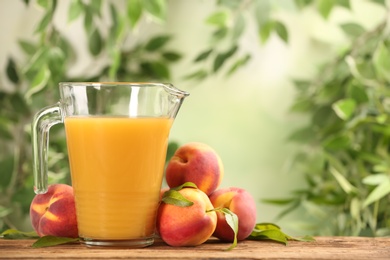 Photo of Natural peach juice and fresh fruits on wooden table. Space for text