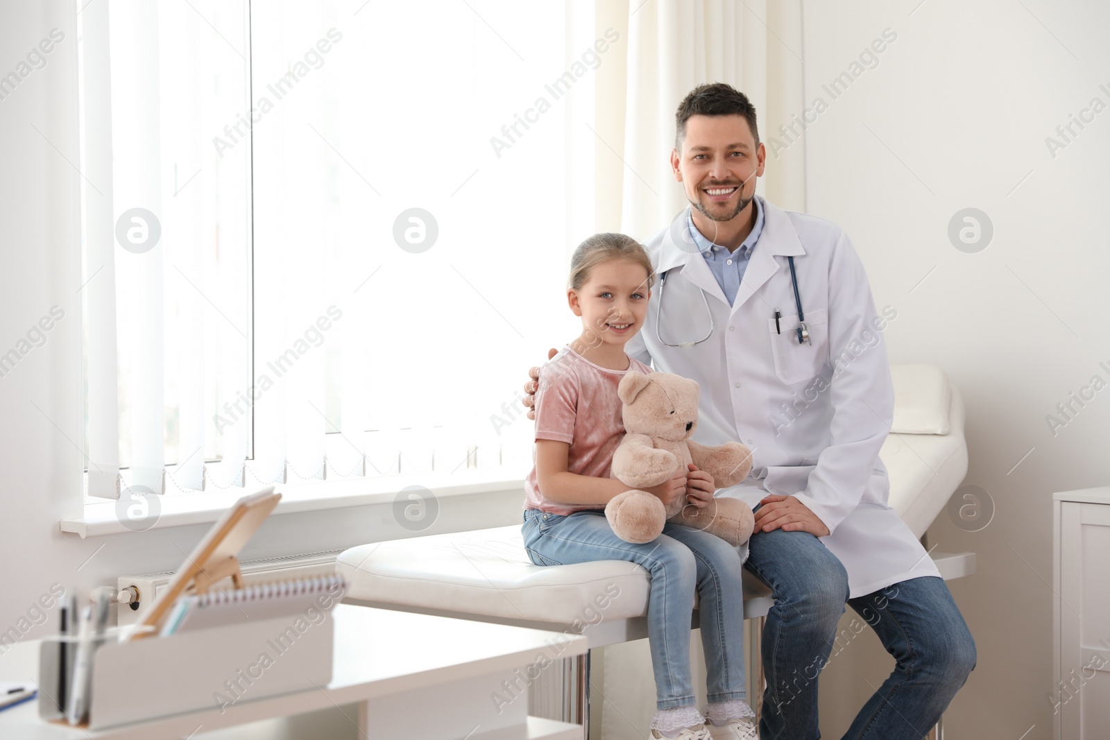 Photo of Children's doctor working with little patient in clinic