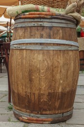 Photo of Traditional wooden barrel on street outdoors. Wine making