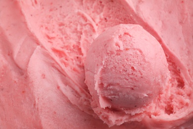 Photo of Scoop of delicious strawberry ice cream in container, closeup