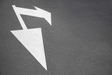 White painted arrow markings on road outdoors, space for text