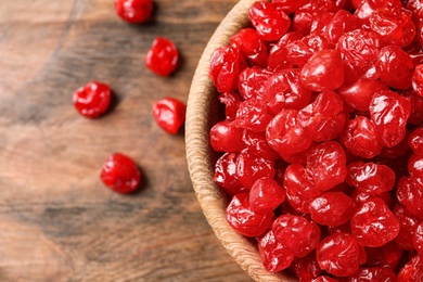 Photo of Bowl of tasty cherries on wooden background, closeup with space for text. Dried fruits as healthy food