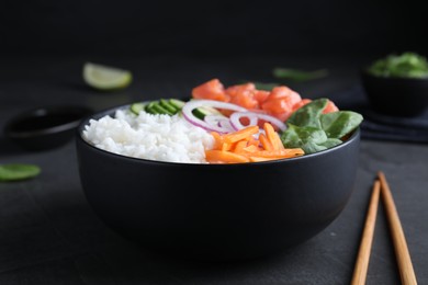 Photo of Delicious poke bowl with salmon and vegetables served on grey table, closeup