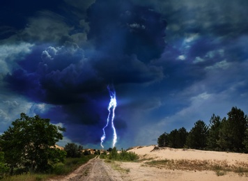 Image of Picturesque thunderstorm in desert. Lightning striking from dark cloudy sky