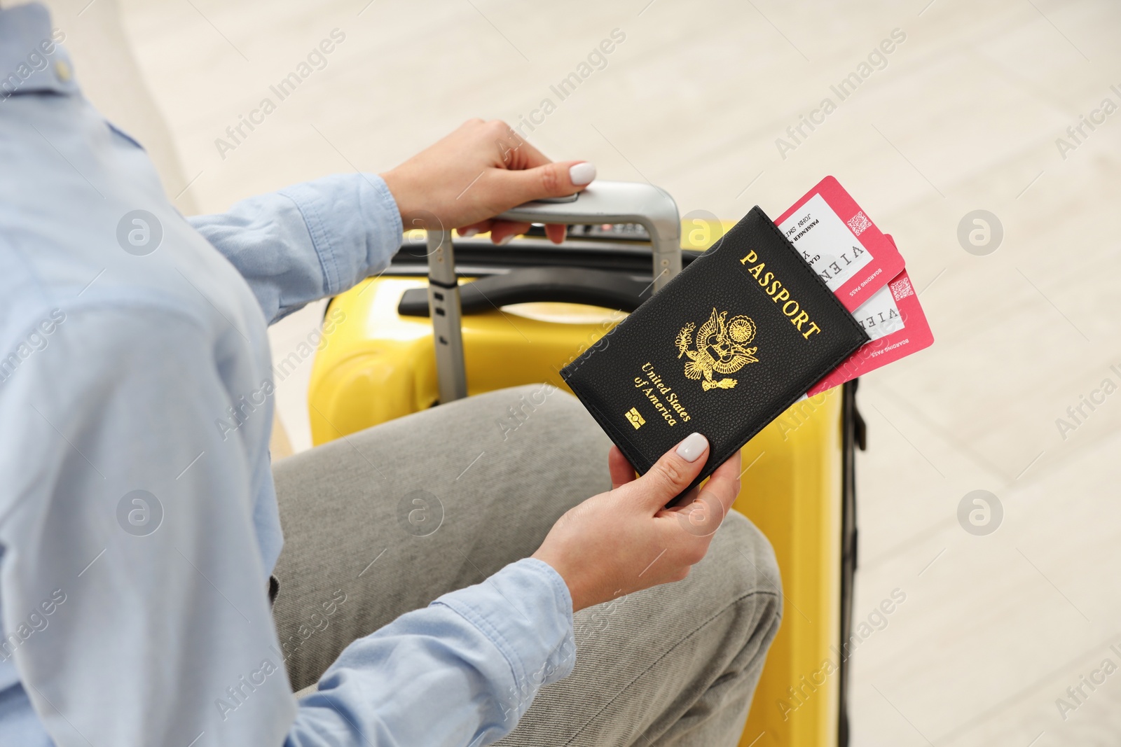 Photo of Woman with suitcase, passport and tickets on blurred background, closeup