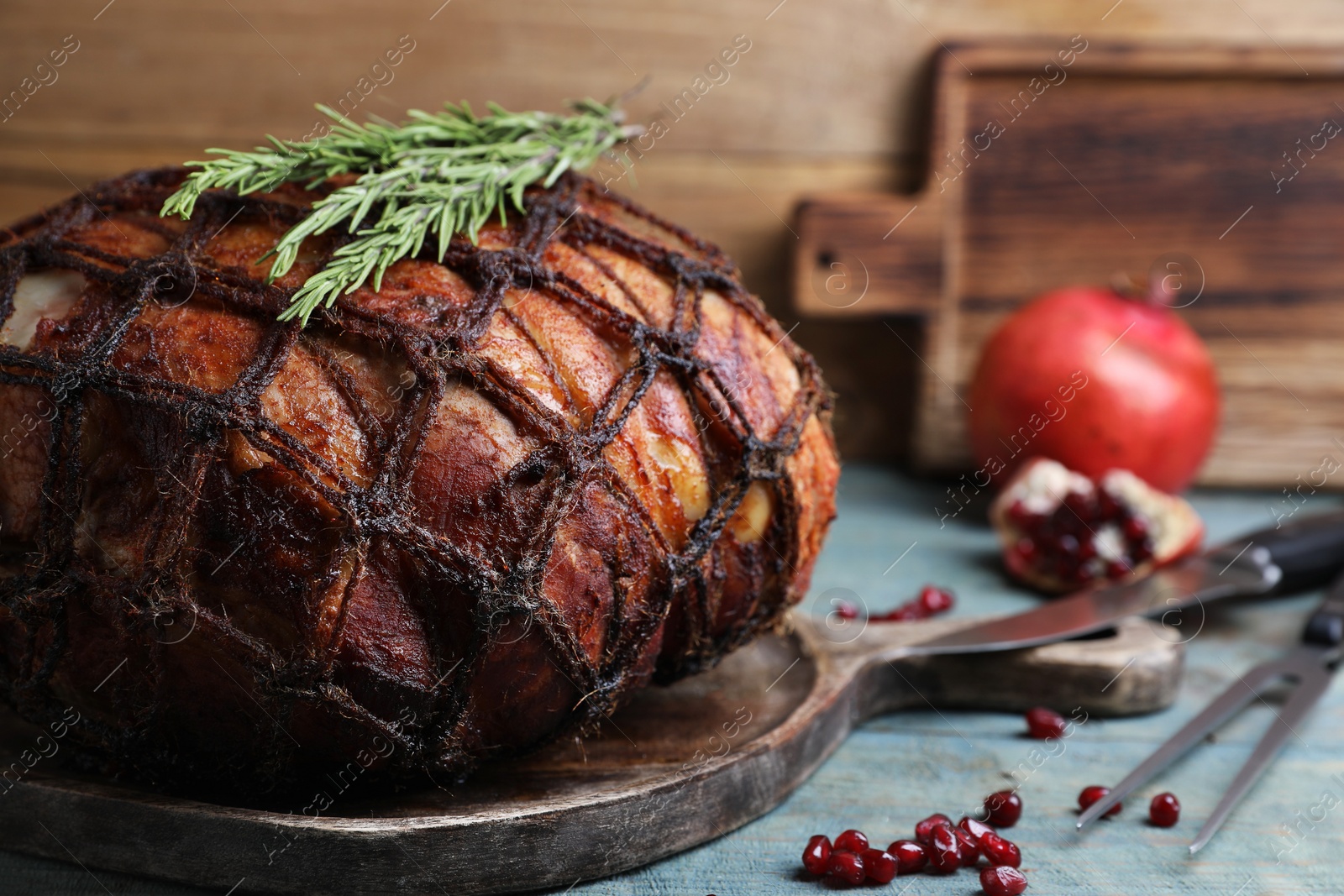 Photo of Delicious baked ham, pomegranate seeds and rosemary on rustic wooden table, closeup