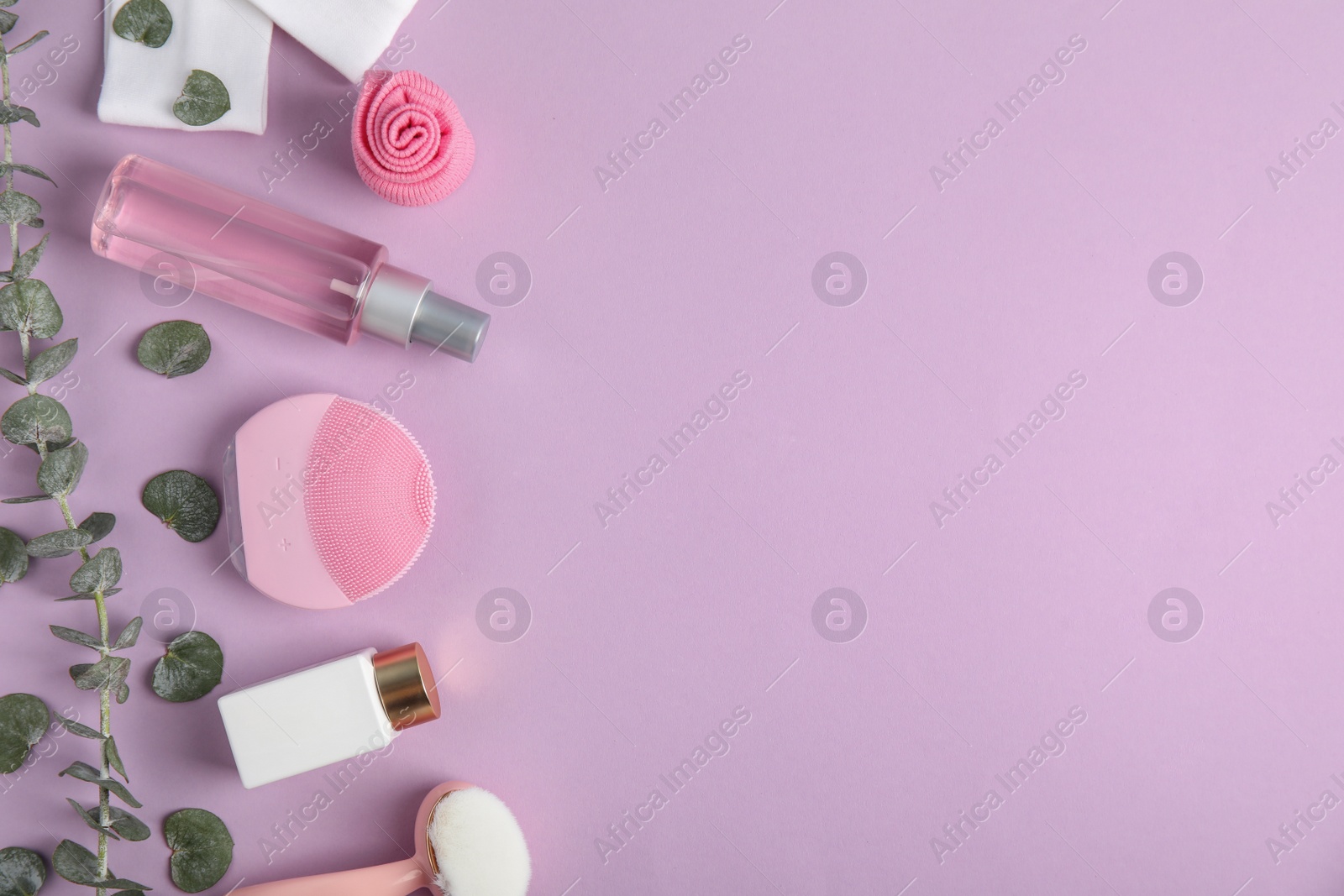 Photo of Flat lay composition with face cleansing brushes on violet background, space for text. Cosmetic accessories
