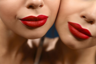 Photo of Beautiful woman with red lipstick near mirror, closeup