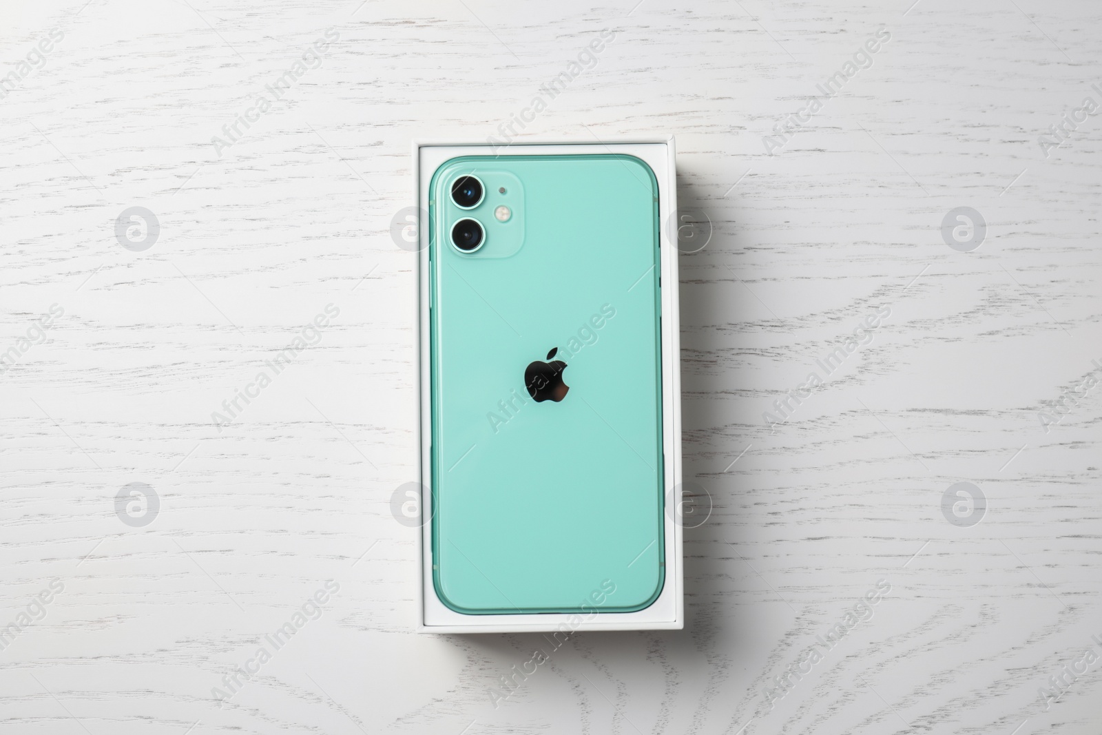 Photo of MYKOLAIV, UKRAINE - JULY 10, 2020: New modern Iphone 11 Green in original box on white wooden table, top view