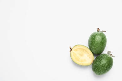 Cut and whole feijoas on white background, top view