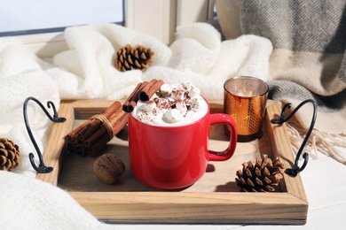 Tray with cup of cocoa on windowsill. Winter drink