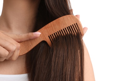 Photo of Young woman with wooden hair comb on white background, closeup