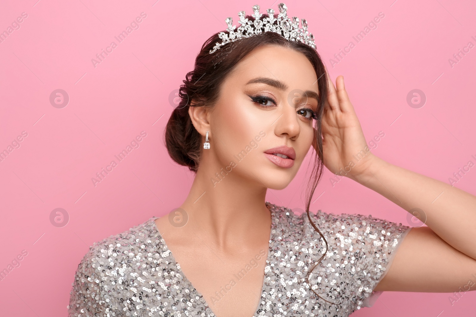 Photo of Beautiful young woman wearing luxurious tiara on pink background