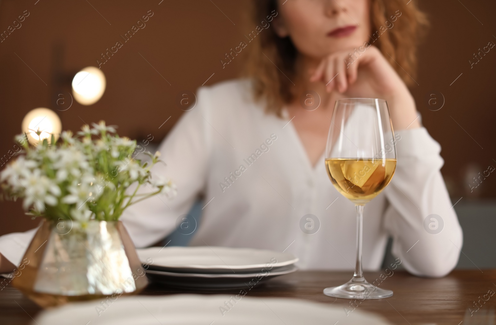 Photo of Woman with glass of wine at table in restaurant