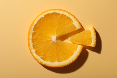 Photo of Slices of juicy orange on beige background, top view