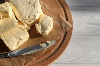 Photo of Tray with tasty homemade butter and knife on white wooden table, top view