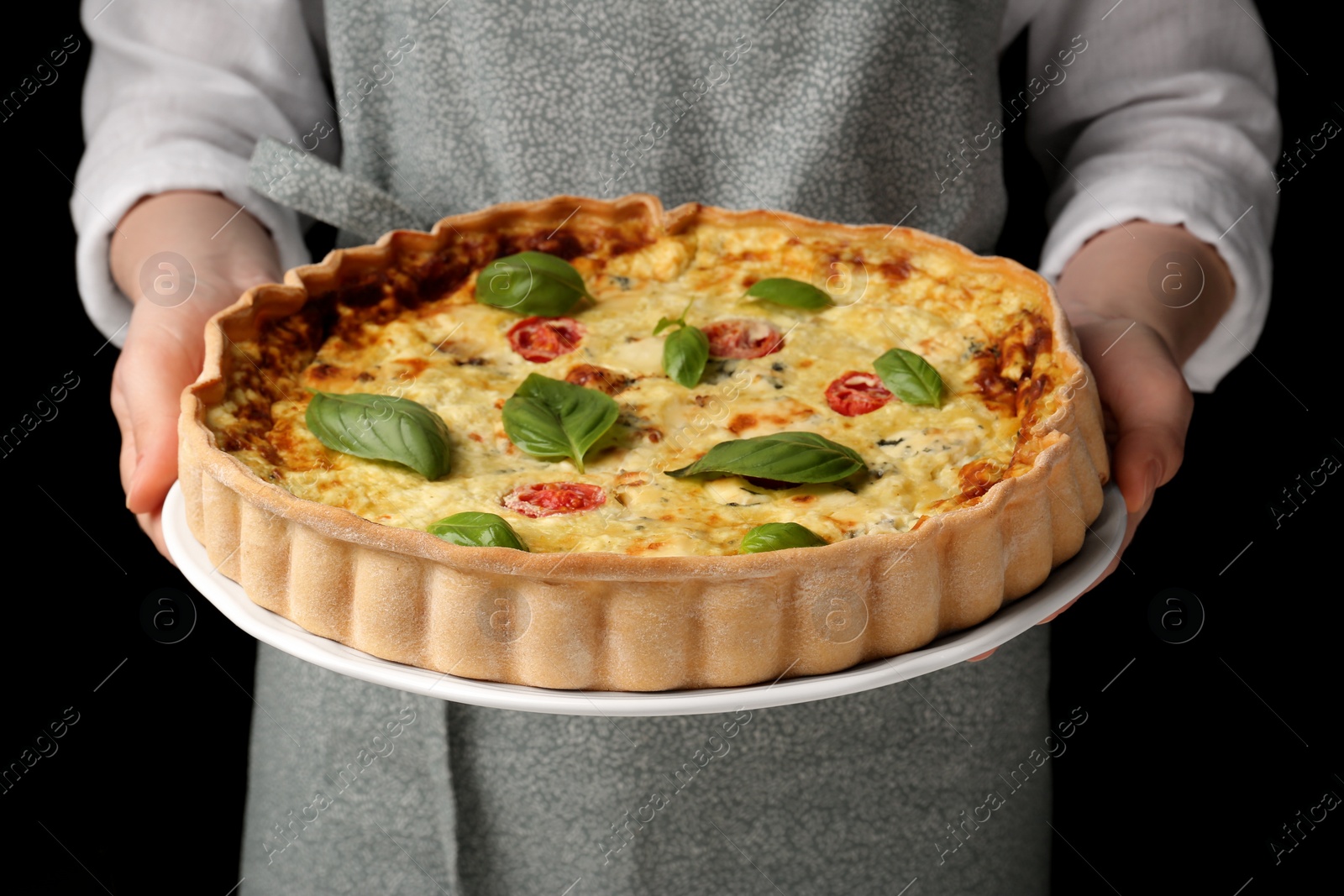 Photo of Woman with delicious homemade cheese quiche on black background, closeup