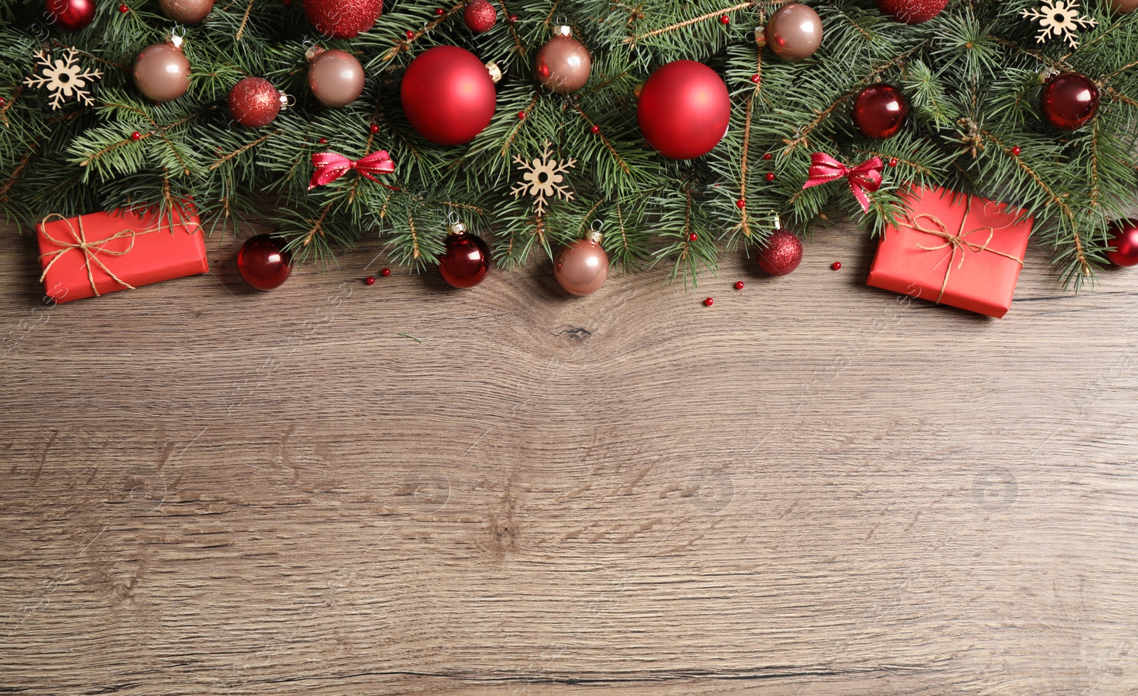 Photo of Fir tree branches with Christmas decoration on wooden background, flat lay. Space for text