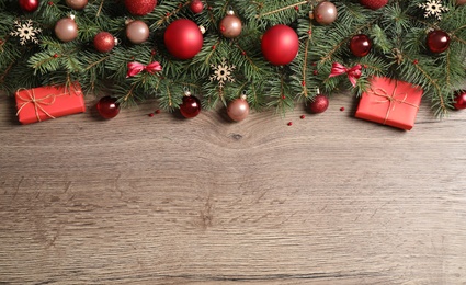 Photo of Fir tree branches with Christmas decoration on wooden background, flat lay. Space for text