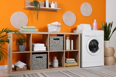 Photo of Stylish laundry room with washing machine. Interior design