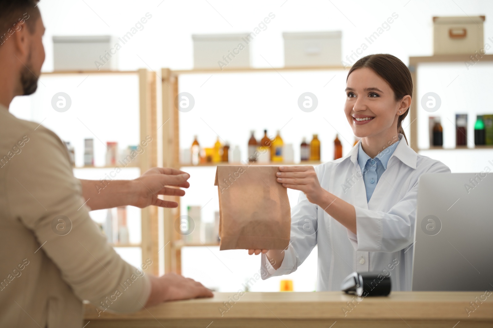 Photo of Pharmacist giving medicine to customer in drugstore