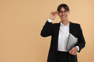 Photo of Happy secretary with laptop on beige background. Space for text