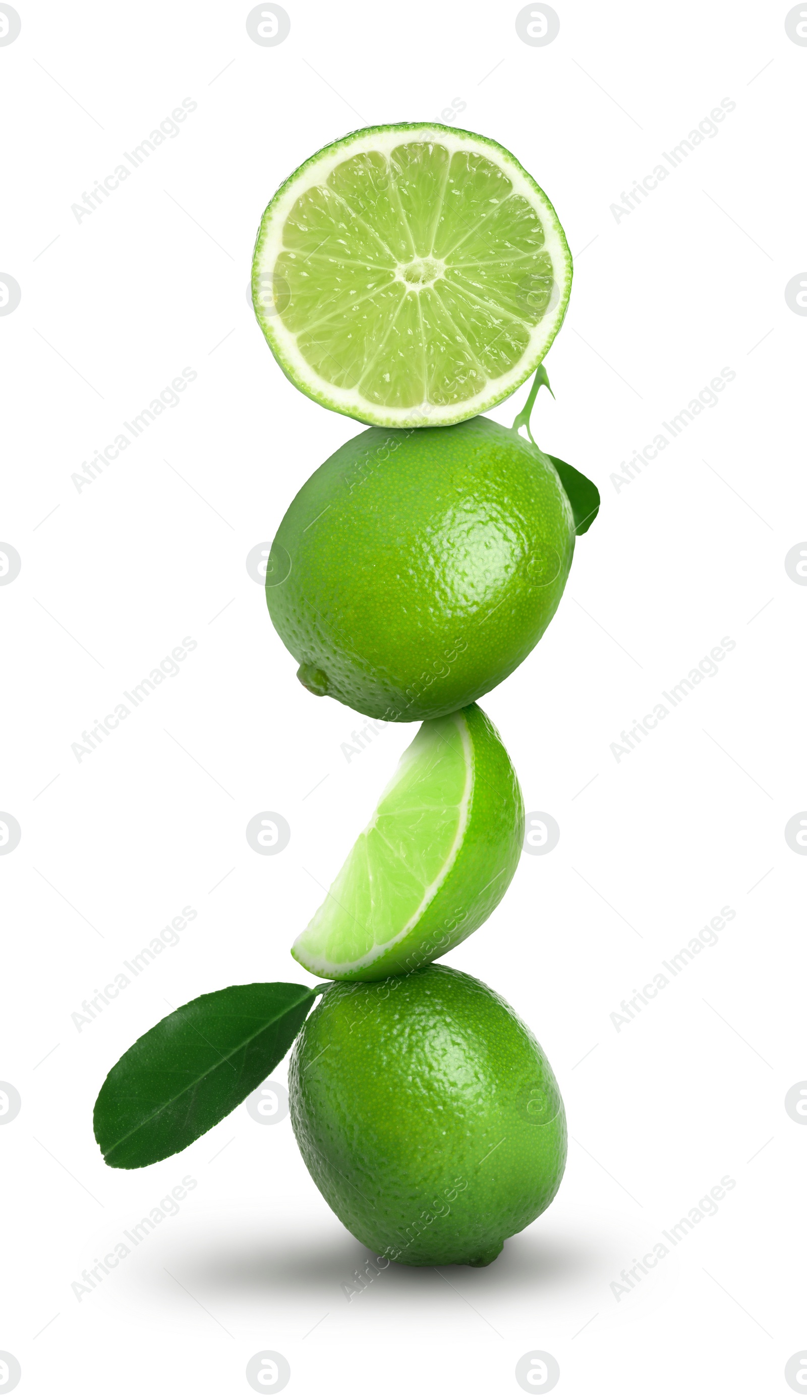 Image of Stacked whole and cut limes on white background