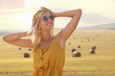 Portrait of beautiful happy hippie woman in field, space for text