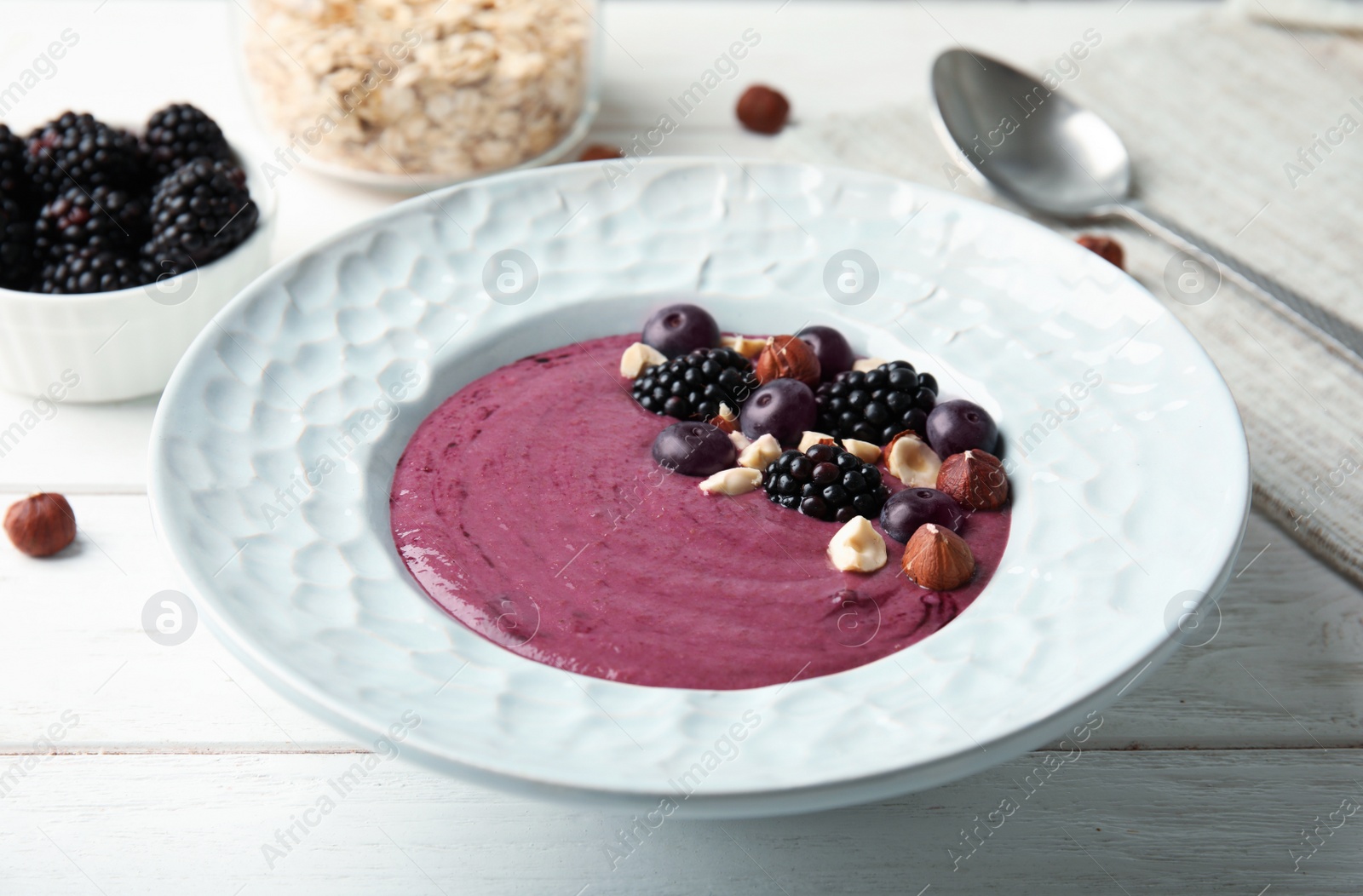 Photo of Plate of tasty acai smoothie on wooden table