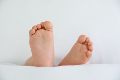 Photo of Cute little baby lying on bed, closeup of feet