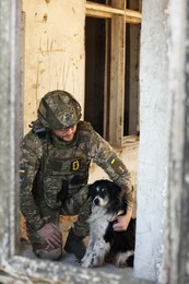 Photo of Ukrainian soldier with stray dog in abandoned building