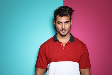 Young man with trendy hairstyle posing on color background